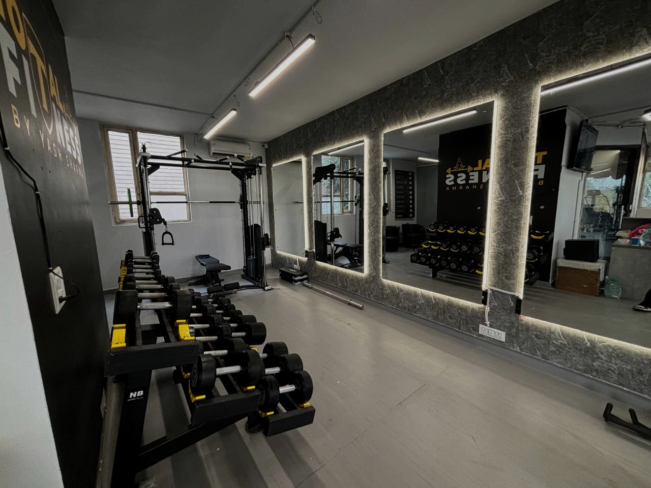 Free weights and mirror wall at Total Fitness Lajpat Nagar